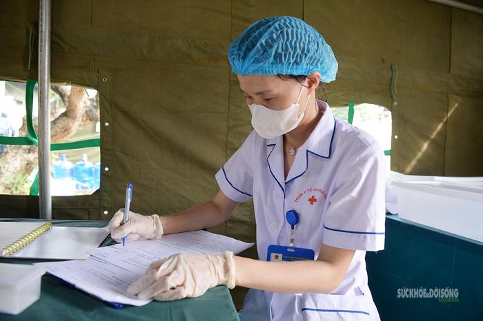 Nhân viên y tế đối chiếu, ghi chép thông tin từng trường hợp. Ảnh: Tuấn Anh