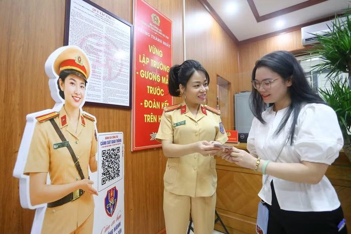 Nụ cười rạng rỡ của người dân khi nhận tấm giấy phép lái xe từ tay nữ cán bộ Cảnh sát giao thông. Bắt đầu từ sự tiếp đón thân thiện, mỗi tấm giấy phép được trao đi là một lời cam kết đồng hành cùng người dân trên mọi chặng đường an toàn