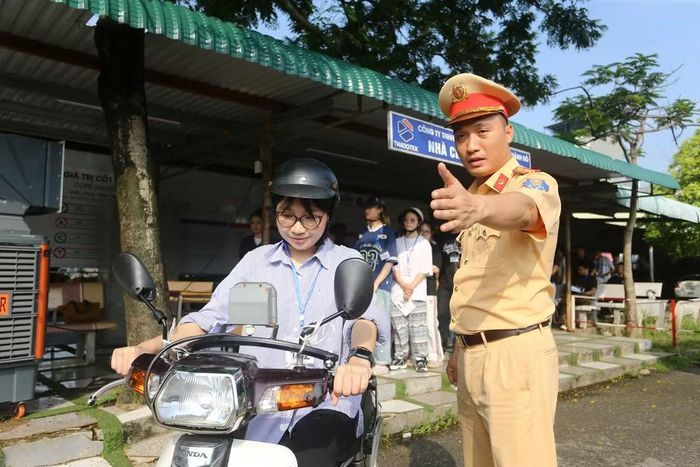 Cán bộ Cảnh sát giao thông tận tình hướng dẫn thao tác và nhắc nhở kỹ năng lái xe an toàn cho thí sinh trước lượt thi thực hành xe máy. Những chỉ dẫn chi tiết, gần gũi giúp người dân tự tin hoàn thành tốt bài thi sa hình