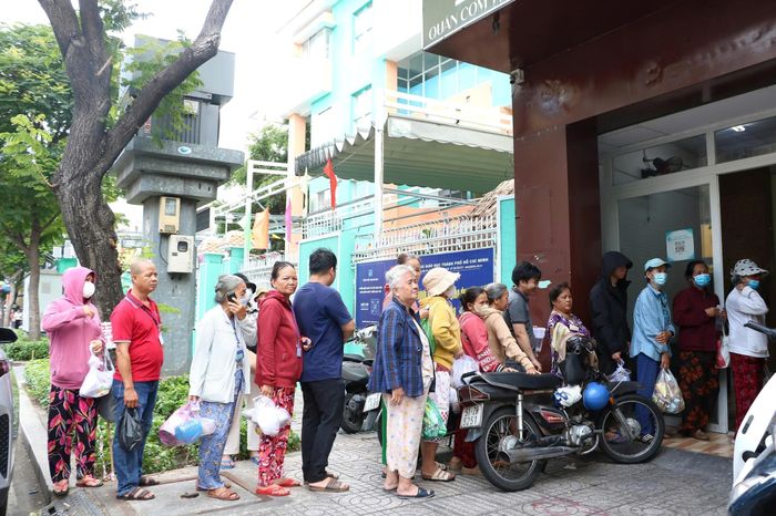 Bệnh nhân, người nuôi bệnh xếp hàng chờ nhận cơm tại quán.