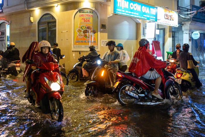  Sau hơn 2 giờ mưa lớn, cuộc sống của người dân ở nhiều khu vực quanh đường Nguyễn Gia Trí, Ung Văn Khiêm vẫn chưa thể trở lại bình thường. Trên đường, người dân tiếp tục tìm cách đưa xe qua những đoạn nước còn đọng, một số gia đình vẫn dọn dẹp phần nước tràn vào nhà. 