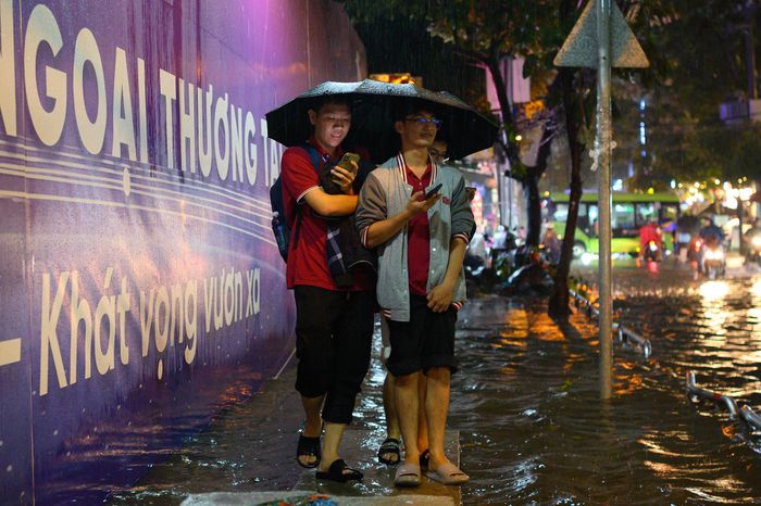  Tan học giữa lúc mưa lớn, nhiều sinh viên phải lội qua dòng nước, dắt xe tìm đường về nhà khi các tuyến đường ở quận Bình Thạnh cũ ngập sâu. 