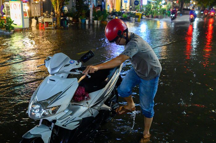  Xe máy bắt đầu gặp sự cố khi cố vượt qua các điểm ngập. Người dân phải đưa xe vào sát lề để kiểm tra, tìm cách vượt qua khu vực ngập. Cảnh người dắt xe xuất hiện liên tục trên Ung Văn Khiêm trong buổi chiều tối mưa lớn. 