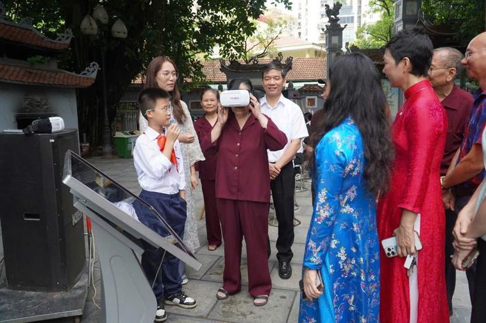 Học sinh Văn Huy Hoàng (ngoài cùng bên trái) hướng dẫn mọi người sử dụng thiết bị. Ảnh: TCG