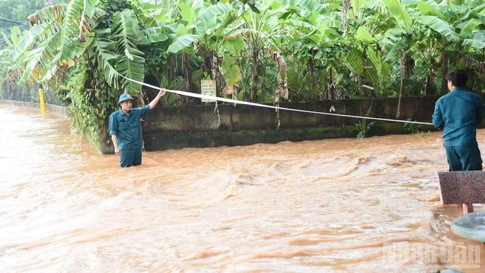Lực lượng dân phòng phường Phước Tân căng dây cảnh báo người dân không qua khu vực ngập. (Ảnh: THIÊN VƯƠNG)