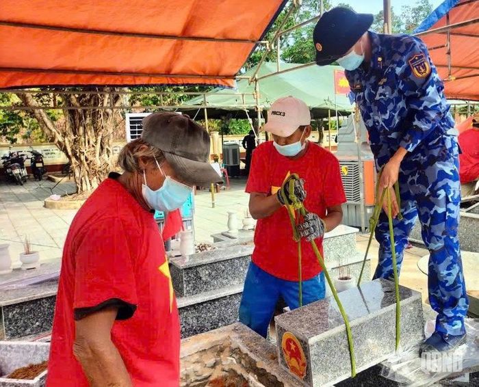 Thành viên tổ công tác thuộc Bộ tư lệnh Vùng Cảnh sát biển 2 phối hợp tiến hành lấy mẫu sinh phẩm hài cốt liệt sĩ tại Nghĩa trang Liệt sĩ Đại Chánh.