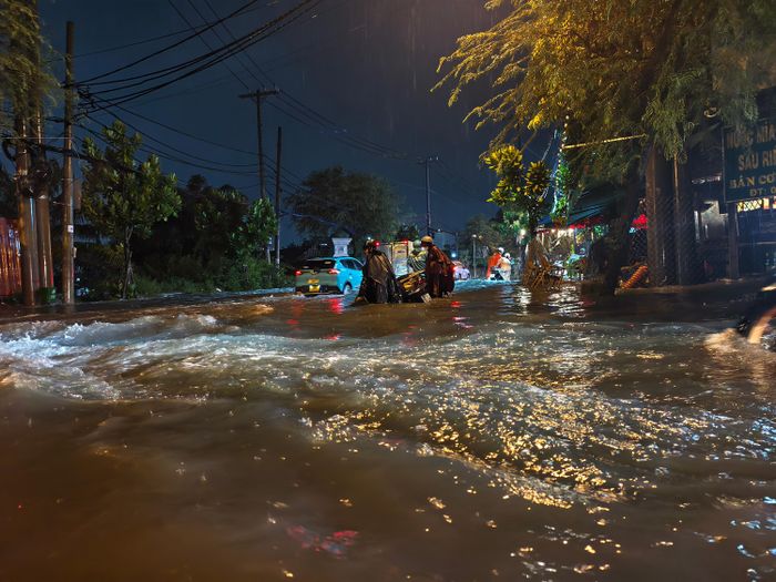  Ở một số nơi, nước chảy xiết khiến xe máy di chuyển khá vất vả. Ảnh: NGUYỄN TÂN 