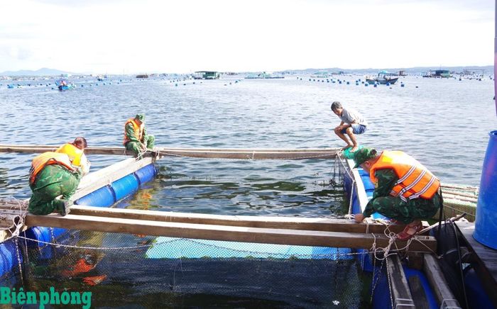 Đồn Biên phòng Cam Ranh hỗ trợ các hộ nuôi trồng thủy sản gia cố lồng bè trên vịnh Cam Ranh. Ảnh: Văn Tân