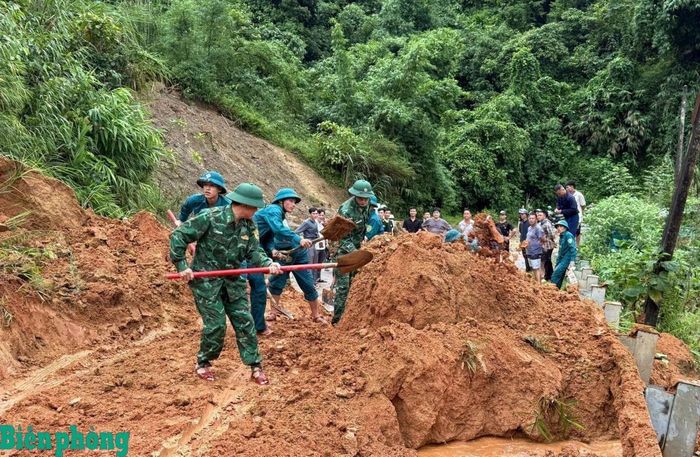 Cán bộ, chiến sĩ Đồn Biên phòng Trung Lý, Bộ đội Biên phòng tỉnh Thanh Hóa cùng các lực lượng tại địa phương khắc phục sạt lở đất trên tuyến quốc lộ 15C sau bão số 4 (bão Narra). Ảnh: Đơn vị cung cấp