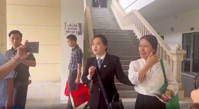 Cô Nguyễn Thị Bình và luật sư rời phiên tòa.