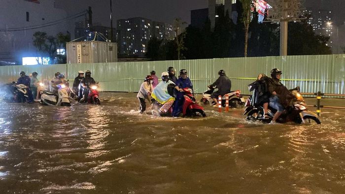  Nước ngập khiến các phương tiện phải di chuyển chậm, một số xe máy gặp khó khăn khi đi qua những đoạn có mực nước cao. 