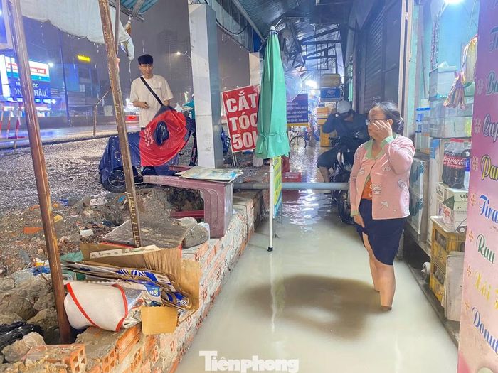 Cơn mưa lớn chiều nay khiến nước từ mặt đường tràn vào nhà người dân ven Quốc lộ 13, đoạn qua phường Lái Thiêu, TPHCM. Nền đường sau khi nâng cấp cao hơn nền nhà khoảng 1 m khiến việc thoát nước gặp khó khăn. Chị Cẩm Châu (43 tuổi), một người dân sống ven Quốc lộ 13, cho biết: "Mỗi khi mưa lớn, nước thường đọng trước nhà rồi tràn vào bên trong, gây ảnh hưởng đến sinh hoạt của gia đình"