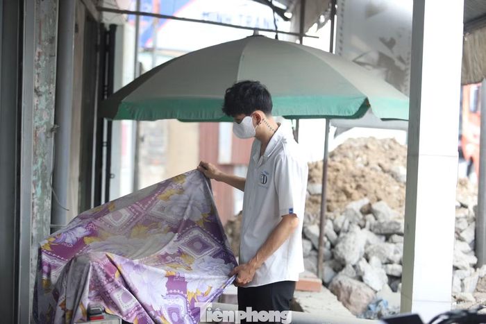 Bụi phủ đầy chiếc xe máy của người dân sống ven Quốc lộ 13. Nhiều gia đình phải dùng chăn phủ lên tài sản, vật dụng trong nhà để hạn chế bụi bám.