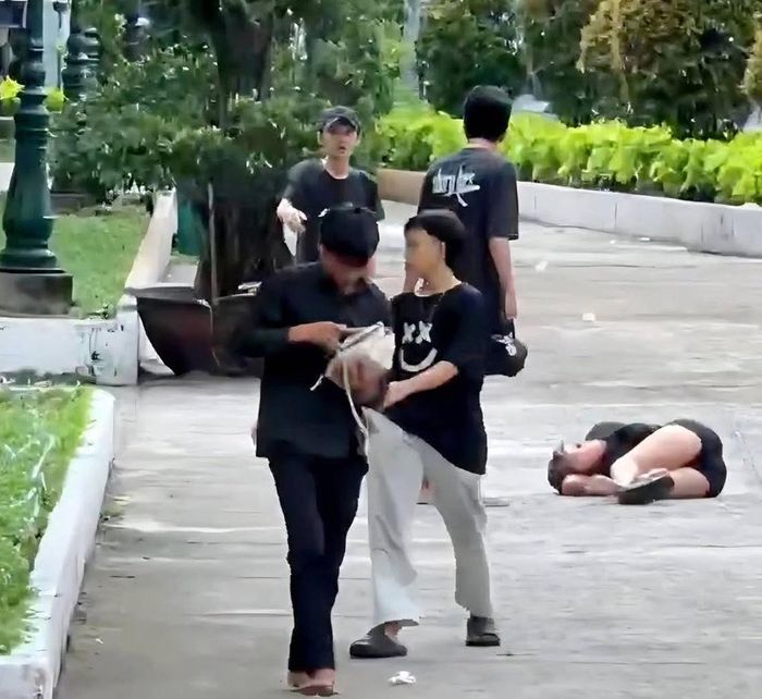 Nhóm thanh niên mặc áo đen hành hung cô gái và cướp đi chiếc túi xách. Ảnh cắt từ clip