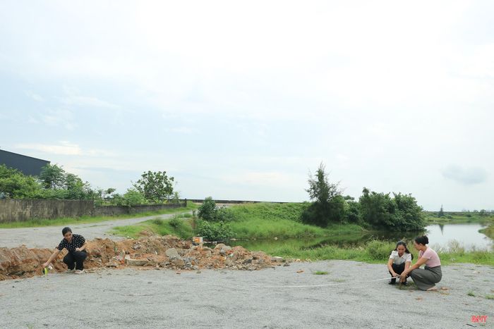 Chị Hạnh trực tiếp kiểm tra, đo đạc để khơi thông rãnh thoát nước tại khu dân cư.