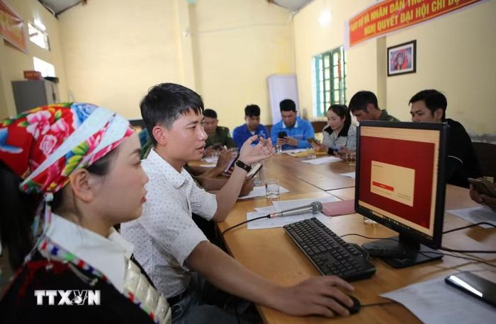 Hướng dẫn người dân thôn Sơn Hà, xã Bát Xát thực hiện nộp hồ sơ trực tuyến trên cổng dịch vụ công. (Ảnh: TTXVN phát)
