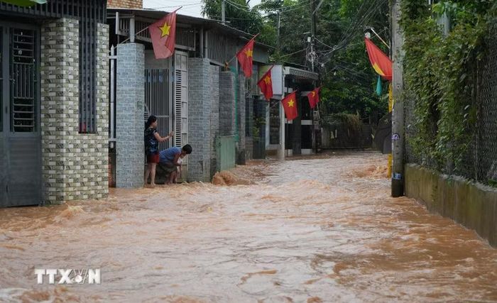 Nhiều người dân ở phường Phước Tân, thành phố Đồng Nai đang cố ngăn dòng nước lũ chảy vào nhà. (Ảnh: Lê Xuân/TTXVN)