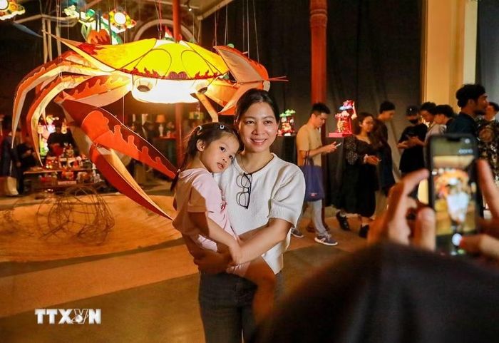 Khách tham quan thích thú khám phá những món đồ chơi gắn với Tết Trung thu truyền thống. (Ảnh: Khánh Hòa/TTXVN)