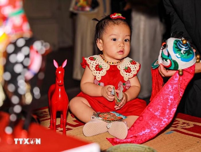 Em nhỏ thích thú với các món đồ chơi trung thu truyền thống.(Ảnh: Khánh Hòa/TTXVN)