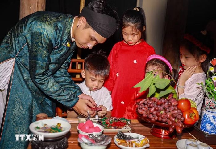 Em nhỏ thích thú với các món đồ chơi trung thu truyền thống. (Ảnh: Khánh Hòa/TTXVN)