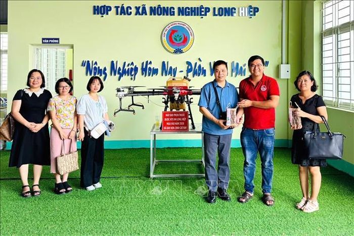 Anh Trần Minh Thuần (thứ 2, từ phải sang) đón Đoàn khảo sát của Học viện Nông nghiệp Việt Nam tại Hợp tác xã Nông nghiệp Long Hiệp. Ảnh: TTXVN phát