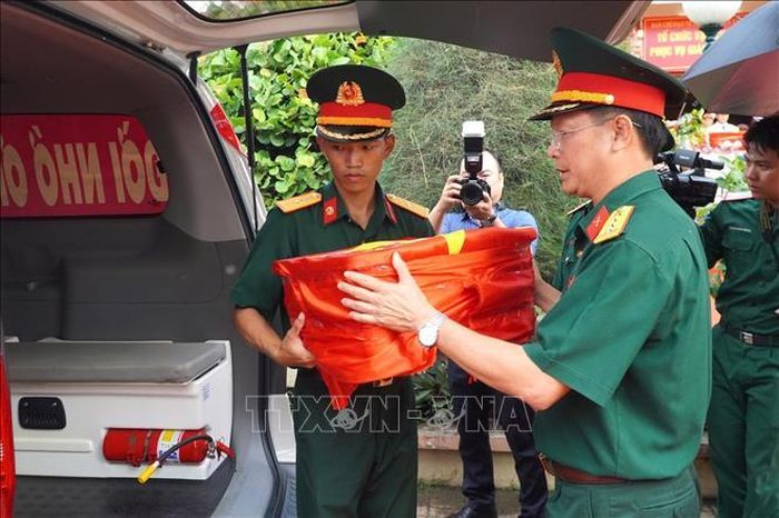 Đại tá Nguyễn Minh Tấn, Phó Chính ủy Bộ Chỉ huy Quân sự tỉnh Tây ninh, cẩn trọng đưa những hộp mẫu sinh phẩm hài cốt liệt sĩ lên xe chuyên dụng. Ảnh: TTXVN phát