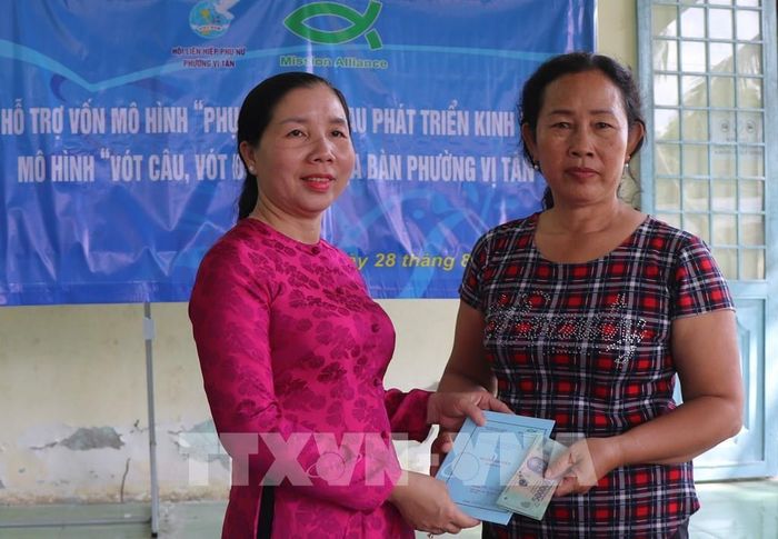 Trao sổ thành viên và nguồn vốn hỗ trợ có hoàn lại cho chị em phụ nữ ở phường Vị Tân. Ảnh: Nguyễn Hằng - TTXVN
