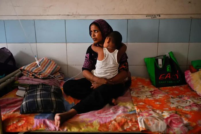 Một phụ nữ chăm sóc con mình ở bệnh viện. Ảnh: AP/Mahmud Hossain Opu