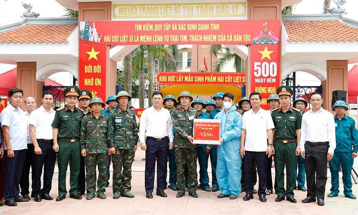  Đồng chí Nguyễn Hồng Thái và các đại biểu tặng quà động viên các lực lượng thực hiện nhiệm vụ lấy mẫu ADN liệt sĩ chưa có thông tin tại Nghĩa trang Liệt sĩ Bắc Lý, xã Xuân Cẩm. 