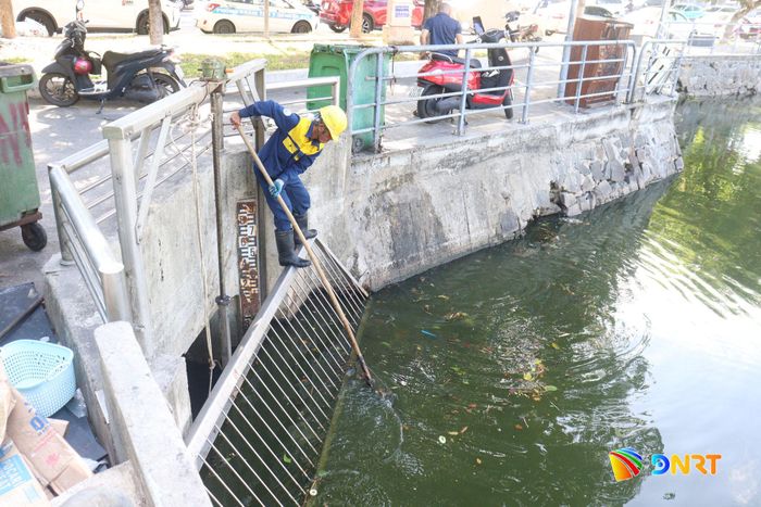 Công nhân Công ty Thoát nước và Xử lý nước thải Đà Nẵng túc trực tại hồ Thạc Gián - Vĩnh Trung để sẵn sàng hạ thấp mực nước hồ trước khi xảy ra mưa lớn. Ảnh: HOÀNG HIỆP