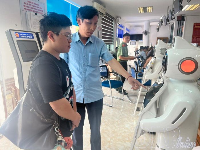 Cán bộ Trung tâm Phục vụ hành chính công phường Điện Biên Phủ hướng dẫn người dân sử dụng Robot AI tra cứu thông tin, thực hiện thủ tục hành chính.