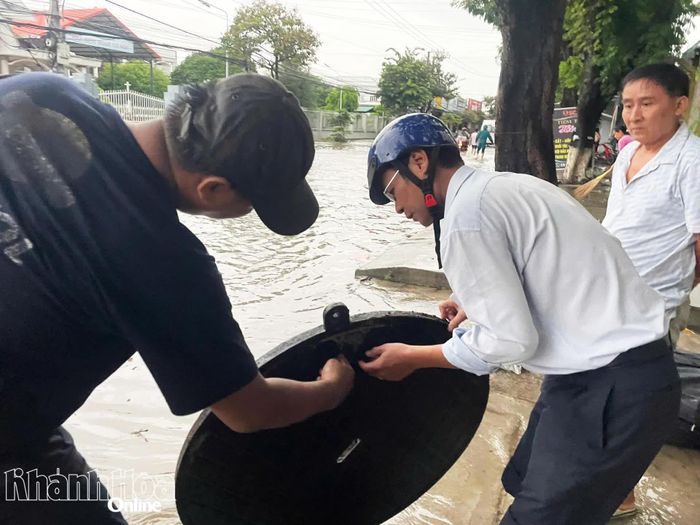 Lãnh đạo phường Ba Ngòi trực tiếp kiểm tra cống thoát nước trên Quốc lộ 1 bị ngập sâu.