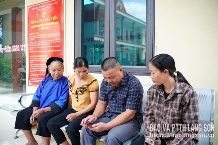Thành viên tổ công nghệ số cộng đồng hướng dẫn người dân sử dụng các ứng dụng số
