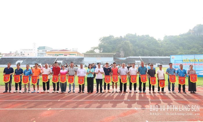 Đại diện Ban tổ chức trao cờ lưu niệm cho các đoàn dự giải
