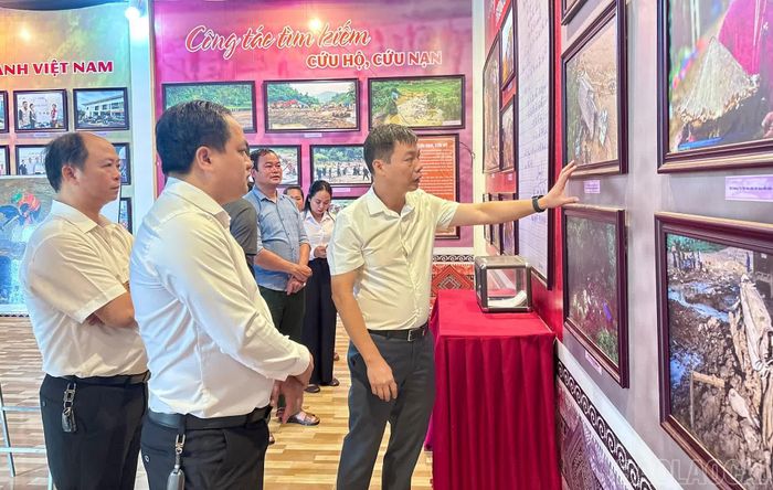 Lãnh đạo địa phương và người dân tham quan các hình ảnh của Làng Nủ sau trận lũ.