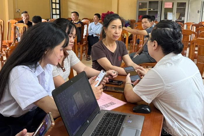 Cán bộ hướng dẫn người dân thực hiện các thủ tục hành chính trên điện thoại thông minh.