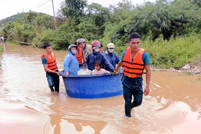 Lực lượng chức năng xã Tà Đùng hỗ trợ người dân di chuyển qua khu vực bị ngập