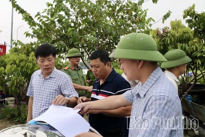 Lực lượng chức năng xã Xuân Lãng kiểm tra, lập biên bản để hộ dân ký cam kết không lấn chiếm, tái lấn chiếm hành lang giao thông.