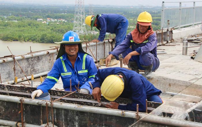 Một nhóm công nhân khác lại phối hợp thi công phần lan can và một số hạng mục khác.