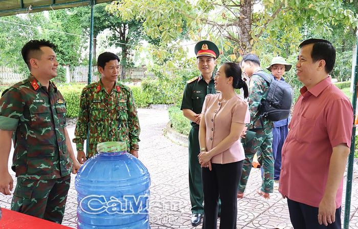 Đại diện lực lượng làm nhiệm vụ trao đổi tình hình lấy mẫu sinh phẩm hài cốt liệt sĩ phục vụ công tác giám định ADN tại Nghĩa trang liệt sĩ Năm Căn với lãnh đạo xã Năm Căn.
