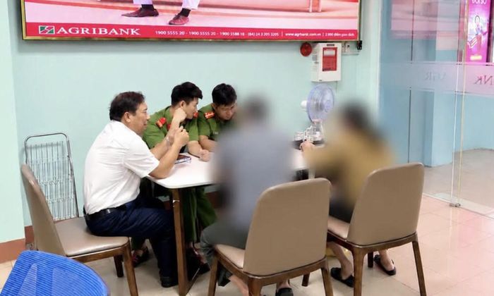 Công an phường Cẩm Thành và nhân viên ngân hàng tuyên truyền, giải thích giúp cặp vợ chồng không bị mắc bẫy lừa đảo và dừng việc giao dịch chuyển tiền.