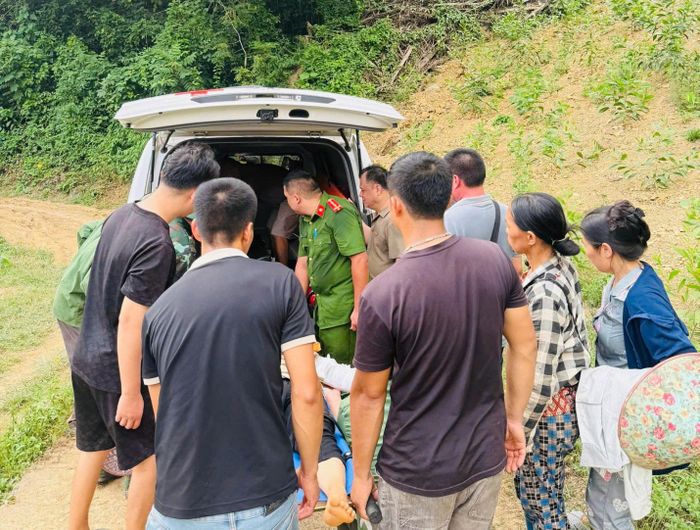 Cán bộ, chiến sĩ Công an xã Điềm He hỗ trợ đưa người bị nạn lên xe cứu thương. (Ảnh: Công an Lạng Sơn).