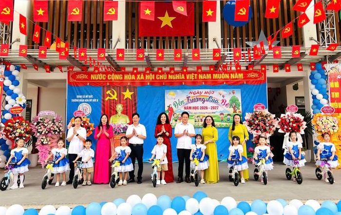 Chủ tịch Hội Chữ thập đỏ xã Mỹ Đức Nguyễn Thị Thu Huyền tặng xe đạp thăng bằng rèn thể chất cho trẻ tại Trường Mầm non Mỹ Đức B. Ảnh: Biên Phạm