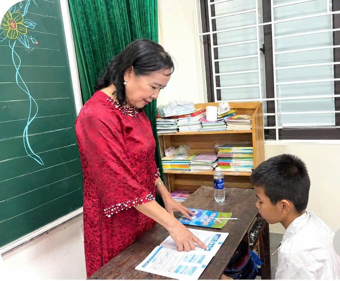 Bà Phạm Thị Huyền tận tình chỉ bảo học sinh từng nét chữ, từng cách tiếp cận để học chữ. Ảnh: Đào Tuyết