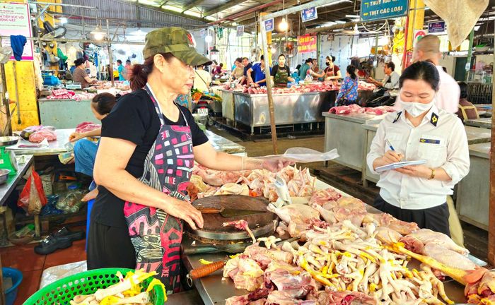 Đoàn kiểm tra số 2 kiểm tra nguồn gốc xuất xứ động vật, sản phẩm động vật của các hộ kinh doanh tại chợ ở phường Việt Hưng. Ảnh: Ánh Dương