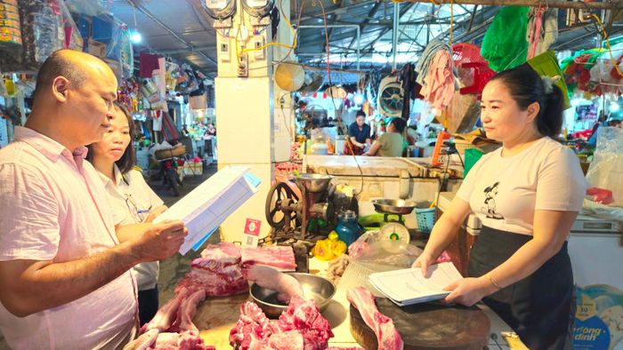 Đoàn kiểm tra số 2 kiểm tra nguồn gốc xuất xứ sản phẩm động vật của các hộ kinh doanh tại chợ ở phường Việt Hưng. Ảnh: Ánh Dương