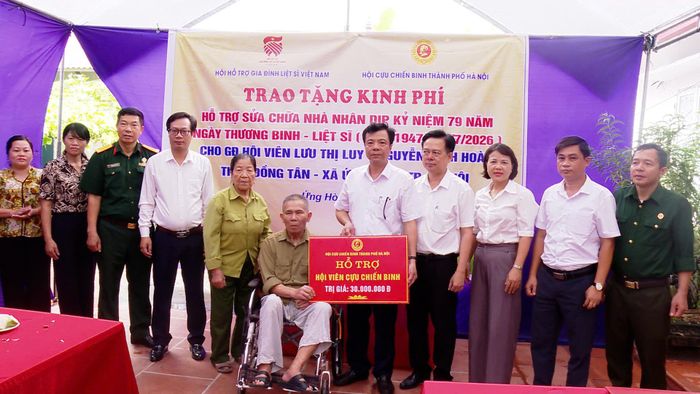 Đại diện xã Ứng Hòa trao kinh phí hỗ trợ xây, sửa nhà cho gia đình khó khăn. Ảnh: Phùng Lương