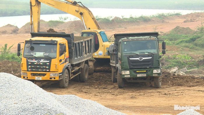 Các xe tải chở đất nạo vét từ lòng hồ Mèo Gù đi đổ ở bãi tập kết tạm nằm trên địa bàn xã Bất Bạt. Ảnh: Thái Trọng.
