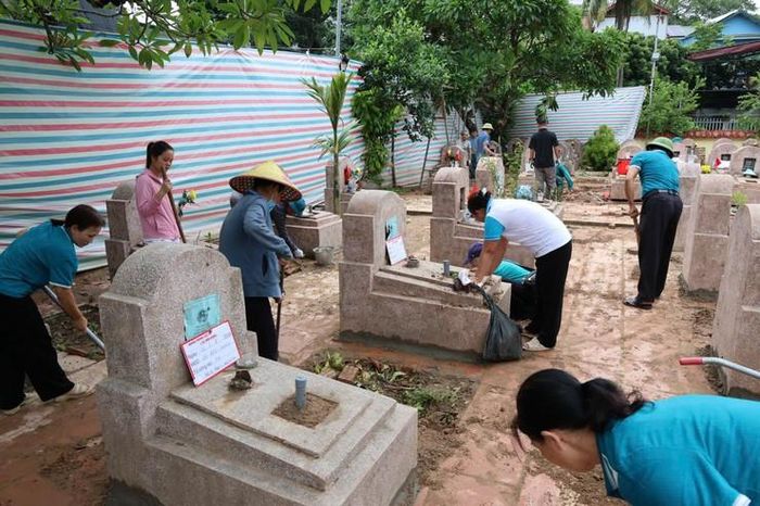 Các đoàn thể xã Tam Hưng cùng vệ sinh, chỉnh trang nghĩa trang. Ảnh: Bình Minh