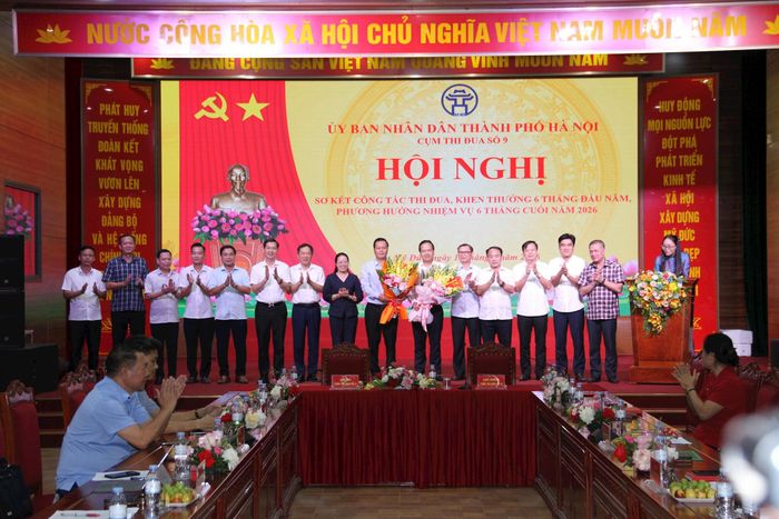 Các đồng chí lãnh đạo các đơn vị trong Cụm thi đua số 9 tặng hoa chúc mừng đồng chí Trần Đức Hải (thứ 9 từ trái qua), nguyên Bí thư Đảng ủy, Chủ tịch HĐND xã Hương Sơn được bổ nhiệm giữ chức vụ Giám đốc Sở Công Thương Hà Nội và đồng chí Ngô Văn Nam (thứ 6 từ phải qua), nguyên Bí thư Đảng ủy, Chủ tịch HĐND phường Đông Ngạc được bổ nhiệm giữ chức Bí thư Đảng ủy xã Hương Sơn. Ảnh: Biên Phạm